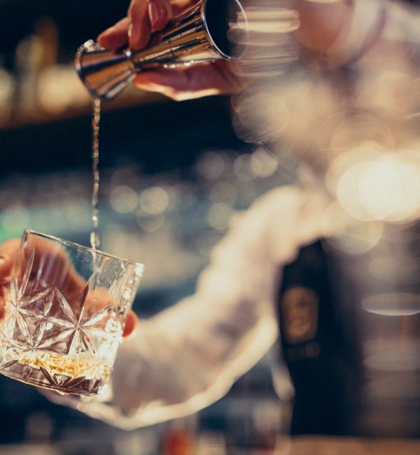 barista-bello-che-fa-bere-e-cocktail-ad-un-contatore_1303-19783